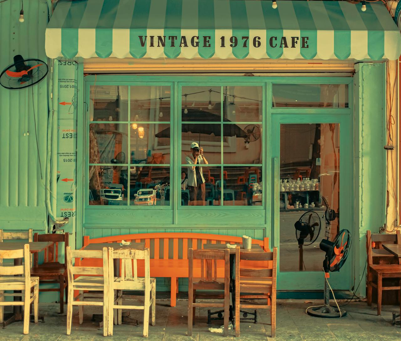 Charming vintage café facade featuring retro chairs and tables in a cozy outdoor setting.
