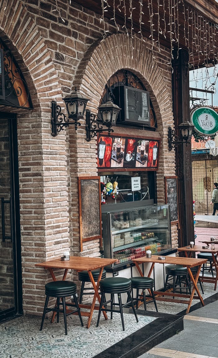 Cozy outdoor café setting with empty tables and rustic brick design.