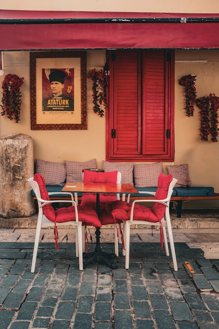 Inviting outdoor cafe featuring red decor and an Atatürk poster, capturing Turkish culture and style.